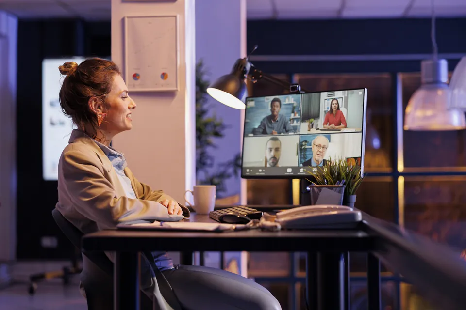 A woman taking part in an evening video call at her desk