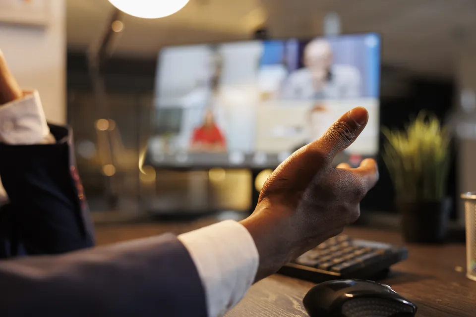 A person taking part in a video conversation at their desk